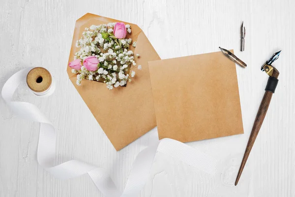Pluma caligráfica un sobre con flores y una carta, tarjeta de felicitación para el día de San Valentín con lugar para su texto. Flat lay, maqueta de fotos vista superior — Foto de Stock