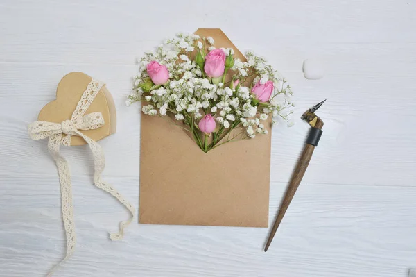 Pluma caligráfica un sobre con flores rosa y una carta — Foto de Stock