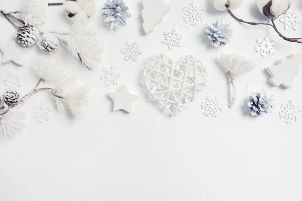 Рождественские открытки с рождественской подарочной коробкой, конусами, цветами хлопка, сердцем, снежинками с местом для текста. Украшения на белом деревянном фоне — стоковое фото