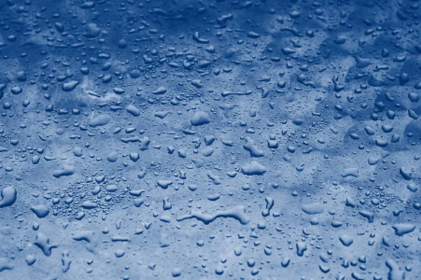 蓝色的水滴纹理在玻璃的背景上。 经典蓝调趋势2020 — 图库照片