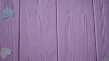 Kurdeleli hediye kutusu ve kalp şeklinde konfeti pembe ahşap arka planda, mesajınız için yer var. Sevgililer Günü 'nde video talebi, anneler günü ya da doğum günü. Üst Görünüm Hd