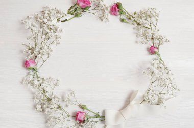 Bahar çiçeği çelengi eski beyaz ahşap arka planda asılı duruyor.