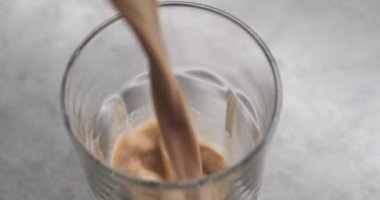 Kahvaltıda bardakta süt akan çikolata. Kahvaltıda meyve, mısır gevreği ve yoğurtla sağlıklı yemek. Macro 4k 2160p 24fps Sinema görüntüleri 4096x2160 video