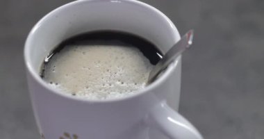 Beyaz köpüklü kahve kapağı ve masada kaşık. Video 4k 4096x2160