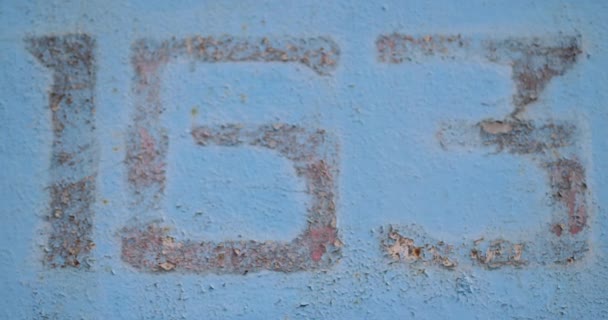 Textura de parede de fundo azul de metal com arranhões e rachaduras e número 163. câmera lisa e lugar para texto. Movimento 4k vídeo, 4096x2160 imagens — Vídeo de Stock