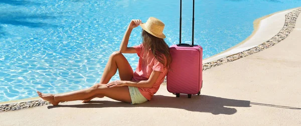 Mulher bonita sentado perto de mala rosa perto da área de piscina do hotel de natação. Viagens, férias de verão e conceito de férias. Cabeçalho panorâmico da paisagem da bandeira — Fotografia de Stock