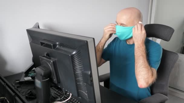 Coronavirus. Hombre trabajando desde casa usando máscara protectora. cuarentena para coronavirus con máscara protectora. Trabajando desde casa — Vídeos de Stock