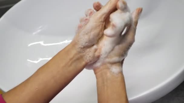 Vrouw wast haar handen om te voorkomen dat ze geïnfecteerd raakt door het wijdverspreide corona virus covid-19. Onherkenbaar persoon wast grondig hun handen met antibacteriële zeep. 4k video real time beelden — Stockvideo