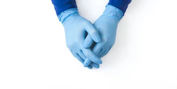 Modrý prapor nitrilových rukavic. Ruce zdravotníka v modrých latexových rukavicích na bílém stole — Stock fotografie