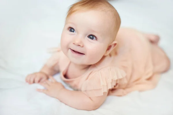 Portrét sladkého dětského úsměvu v růžových šatech ve studiu — Stock fotografie