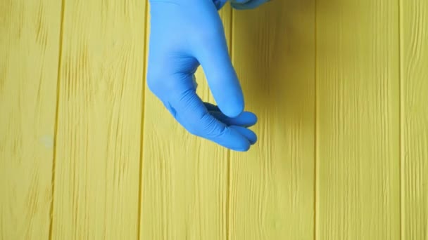 Der Arzt zog blaue sterile OP-Handschuhe über die Hände auf rotem Hintergrund an. Nahaufnahme. Konzept Pandemieversicherung Coronavirus, Hygiene, Schutz der Hände, Virusinfektionskontrolle — Stockvideo