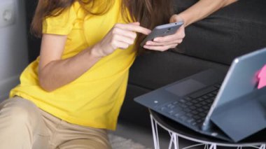 İş yerinde internetten internete göz atan genç bir iş kadını. İş kadınının portresi evde internetten telefon içeriğini kontrol ediyor. Uzaktaki ofisteki kadın serbest çalışan.