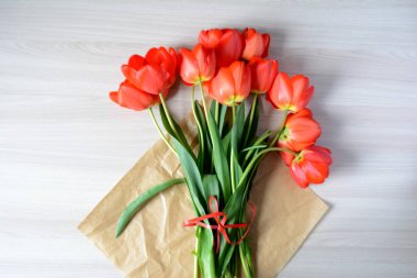 Ahşap arka planda bir buket kırmızı lale. Bahar çiçekleri. Anneler Günü, Sevgililer Günü, Uluslararası Kadınlar Günü, 8 Mart