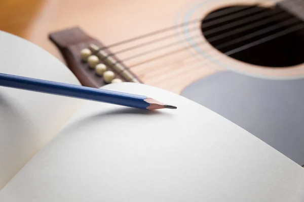 Cuaderno y lápiz en la guitarra, Escribir música —  Fotos de Stock