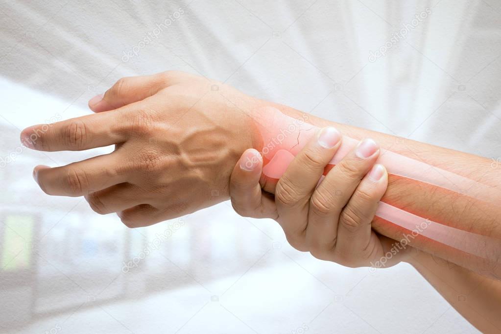 Man massaging painful wrist on a white background. Pain concept