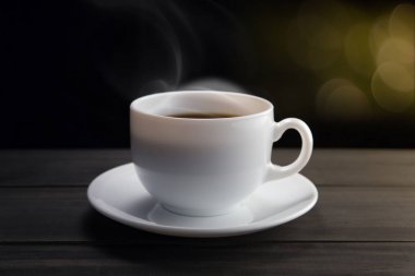 Dumanlı siyah arka plan üzerine beyaz kahve fincanı. Koyu arka plan