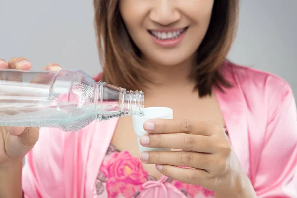 Mooi meisje handen gieten mondwater in fles dop, tandheelkundige H — Stockfoto