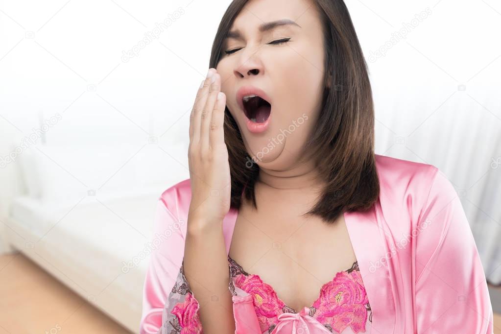Woman yawning at bedroom