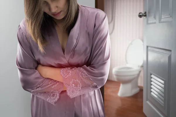 Женщина в фиолетовом атласном халате проснулась и пошла в туалет. . — стоковое фото