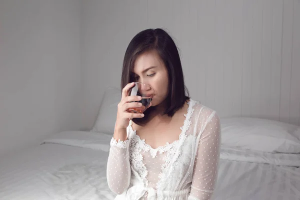 Woman in white nightgown drinking water — Stock Photo, Image