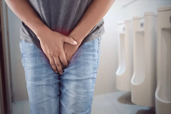 Asian man wants to pee and is holding his bladder. — Stock Photo, Image