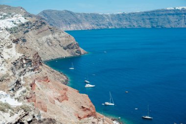 Geleneksel görünümüne Santorini Adası üzerinde beyaz tekne ile mavi denizin kıyıdan