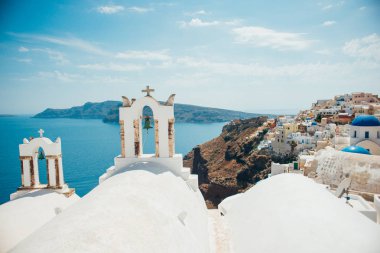 Deniz ve ada iki beyaz çan Kuleli geleneksel görünümünü Santorini üzerinde