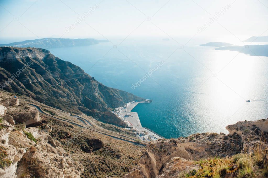 Top view from the island of Santorini to the sea, islands, blue sky, road and port