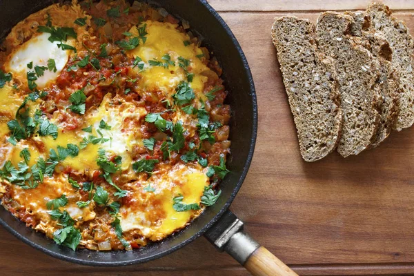 Tahıl ekmek ile bir tavada kızarmış yumurta. Yukarıdan Shakshuka görünümü.