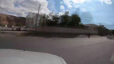 Güneşli ve bulutlu bir günde Muscat 'la Al Amarat yoluna sürmek açık bir gökyüzüne sahip olmak güneşli ve bulutlu bir günde sinematik bir yola sahip açık bir gökyüzüne sahip olmak iki yönlü bir yola ve dağlara sahip bir arabaya sahip olmak