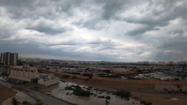 Coronavirus 'tan sonra gelen Muscat yolu. Şirketin inşaat ve avlusunda gündüz vakti bulutlar ve gökyüzü ile birlikte çöl ortasında Azaiba Muscat Umman Şehri.