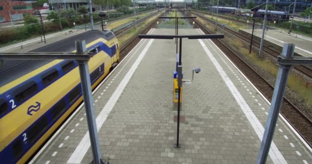 阿姆斯特丹火车站白天运行中的列车和车站的时间档和荷兰斯鲁特迪克火车站的空档 — 图库视频影像