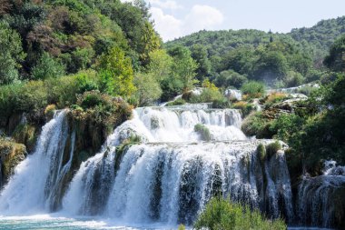 Krka Ulusal Parkı 'nın nefes kesici manzarası, güneşli gün, yaz mevsimi yeşillik ve ağaçlara sahip Hırvatistan