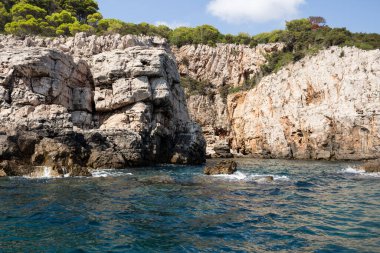 Dubrovnik deniz manzarası uçurum ve kayalıklarla okyanusun ortasından kayalara su sıçrıyor.