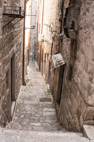 Old city alley, streets, and stairs of Dubrovnik old town, Croatia, Old stone walls on both side, stones on the floor