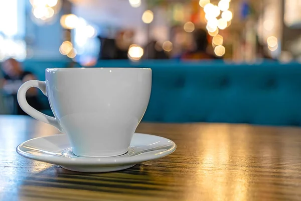 Kafenin yakınındaki ahşap bir masada beyaz bir fincan çay.. 