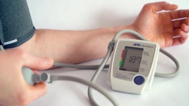 Evdeki elektronik cihazla kan basıncını ölçüyorum..