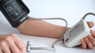 Evdeki elektronik cihazla kan basıncını ölçüyorum..