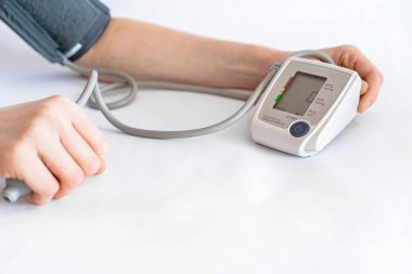 Tansiyon ölçümü. Bir kadın eli ve basıncı ölçmek için bir cihaz.. 