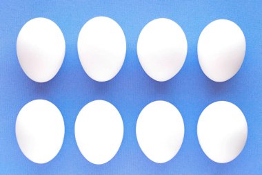 Mavi arka planda beyaz tavuk yumurtaları. Büyük Paskalya