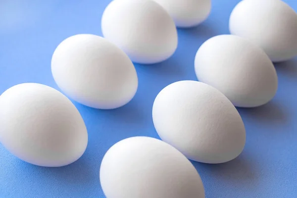 White chicken eggs close-up on a blue background top view. Great Easter — Stock Photo, Image