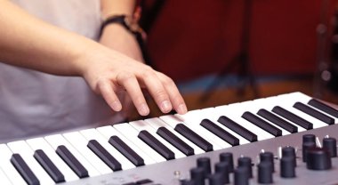 Elektronik sentezleyici ve yakın plan bir kadının elinin parçası..