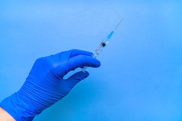 코로나 바이러스 백신이 들어 있는 주사기는 파란색 장갑낀 손으로. — 스톡 사진