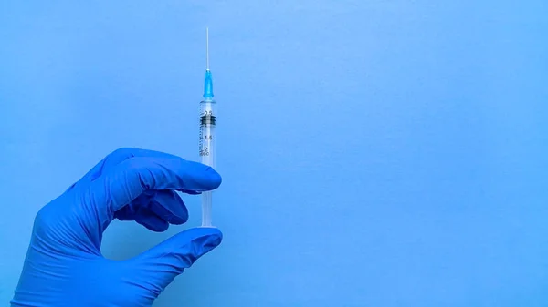 코로나 바이러스 백신이 들어 있는 주사기는 파란색 장갑낀 손으로. — 스톡 사진