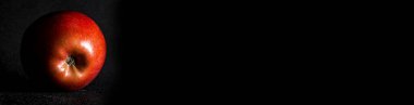 Kırmızı Elma tek bir ışık kaynağıyla siyah arkaplanı kapatır.