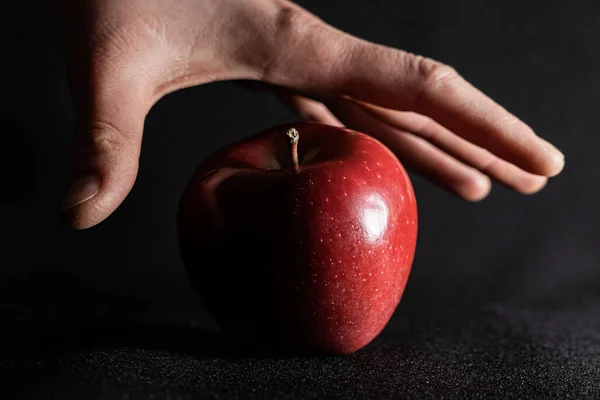 La mano toma una manzana roja . Fotos de stock libres de derechos