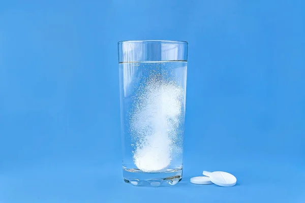 Pastillas efervescentes en un vaso de agua de cerca. Enfoque suave . Imagen de archivo