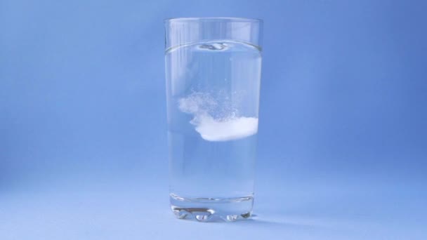 阿司匹林在蓝色底物上的一杯水中溶解 呈泡状的阿司匹林 — 图库视频影像