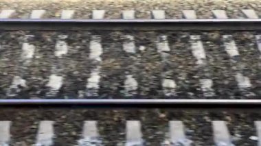 Tren yolu hareket halindeki bir tren penceresinden, trenin raylara ve pusuculara göre hızı...
