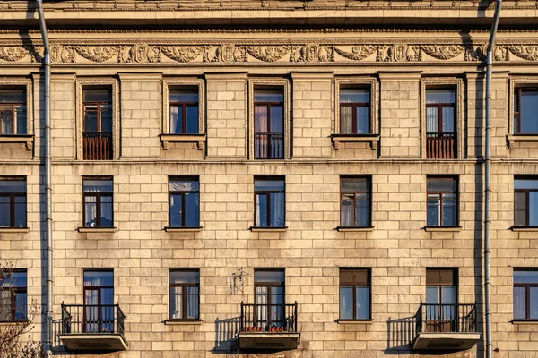 Fönster på gamla byggnader i Sankt Petersburg, bakgrundssymmetri i byggnader. — Stockfoto